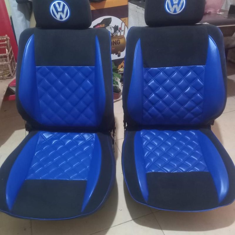 Par de asientos tapizados en piel azul con costura de rombos